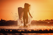 Young Woman Runs With Surfboard With Lots Of Splashes
