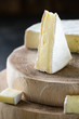 Closeup of soft cheese brie sliced on wooden cuts on dark rustic background