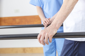 Detail of rehab gym. Elderly people at the bar