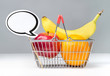 Speech bubble with shopping basket of fruits. Apple, orange and banana in basket with speech balloon. Fun vegan and vegetarian healthy food concept.