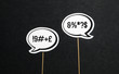 Argument, fight, curse or swearing concept. Disagreement on an online forum or internet. Two speech bubbles argue.. Speech balloon cut from paper of cardboard with wooden stick on a dark background.
