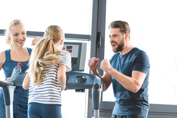 Parents supporting daughter workout on treadmill