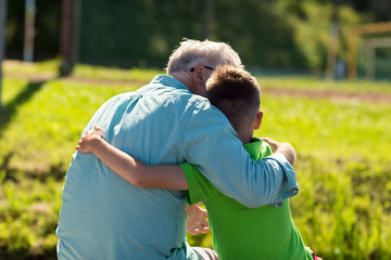 grandfather and grandson hugging outdoors