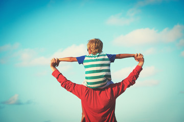 happy father and son playing on sky