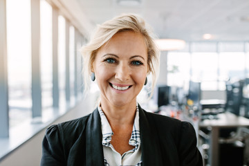 Successful mature businesswoman standing in office