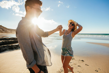 Wall Mural - Beautiful young couple having fun on the beach