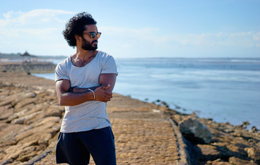 Handsome and confident. Outdoor portrait of young african man on the beach.