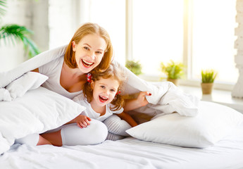 Wall Mural - Happy family mother and child daughter laugh in bed