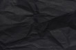 The background paper, crumpled black