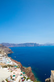 Fototapeta Do akwarium - View of Fira town - Santorini island,Crete,Greece. White concrete staircases leading down to beautiful bay with clear blue sky and sea