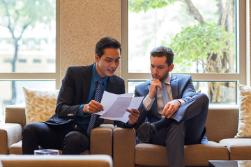 Wall Mural - Two Business Men Discussing Document in Lounge