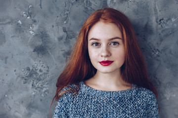 Wall Mural - Portrait of cute beautiful young girl with freckles and red hair close-up. Sensitive red lips.