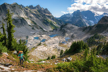 Man Hiking By Mountains In Sunshine, Alpine Lakes, Washington, USA  
