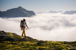 © Jeff Carlson - Man trekking high up in the mountains above the clouds