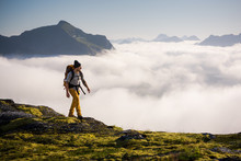 Man Trekking High Up In The Mountains Above The Clouds 