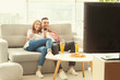 © Africa Studio - Young couple with beer and pizza watching TV at home