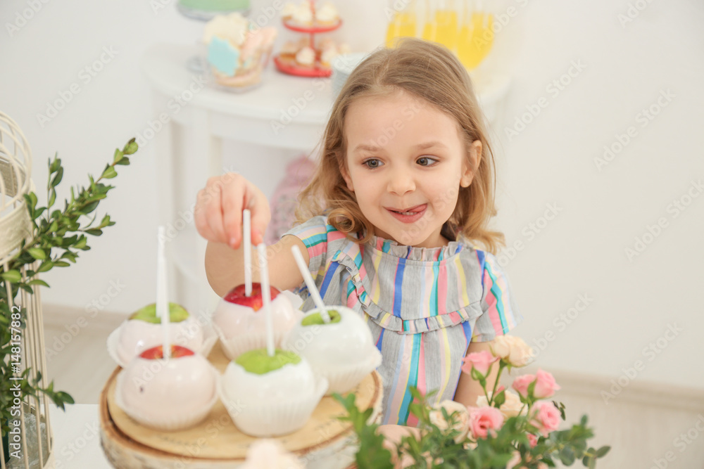 Cute girl taking sweets served for party