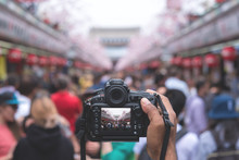 Camera Capturing Senso-ji Temple Walking Street (Nakamise) With Many Tourists In Background.
