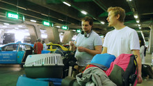 Travelers With Luggage And Traveler Maine Coon Cat In Cage In The Airport Looking For A Taxi. Thailand