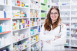 © Karanov images - Pharmacist chemist woman standing in pharmacy - drugstore