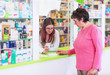 © Karanov images - Female pharmacist discusses prescription medication with senior customer at pharmacy