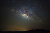 Fototapeta Tęcza - Milky way galaxy with stars over moutain at Phu Hin Rong Kla National Park,Phitsanulok Thailand, Long exposure photograph.with grain