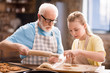 grandfather and granddaughter making dough