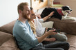 © NDABCREATIVITY - Beautiful couple watching television at home with their dog