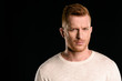 © LIGHTFIELD STUDIOS - portrait of handsome redhead man looking at camera isolated on black