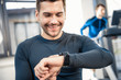 © LIGHTFIELD STUDIOS - Handsome young man using smartwatch at gym