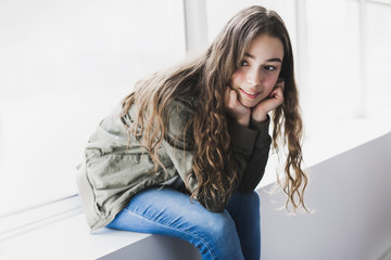 Wall Mural - Teenager girl sitting on window