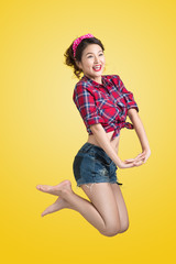 Sexy woman retro portrait  with pin-up make-up and hairstyle posing over yellow background.