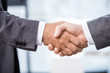 © LIGHTFIELD STUDIOS - Close-up partial view of two businessmen in formal wear shaking hands, business concept