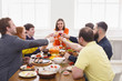 © Prostock-studio - People say cheers clink glasses at festive table dinner party
