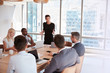 © Monkey Business - Businesswoman Stands To Address Meeting Around Board Table