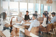 © Monkey Business - Businesswoman Leads Meeting Around Table Shot Through Door