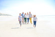 © goodluz - Family, parents, grandparents and grandkids walking on the beach