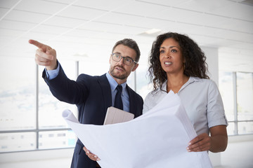 Poster - Businesspeople Meeting To Look At Plans In Empty Office