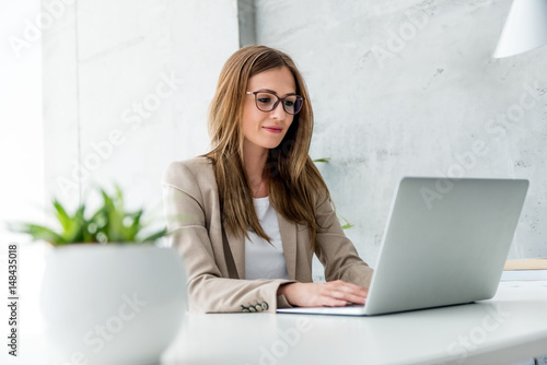 Plakat Piękny bizneswoman pisać na maszynie na laptopie