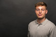 © Wisiel - Man in grey polo t-shirt on black background with smile