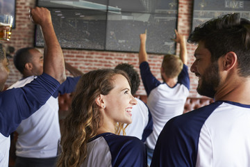 Wall Mural - Rear View Of Friends Watching Game In Sports Bar On Screens