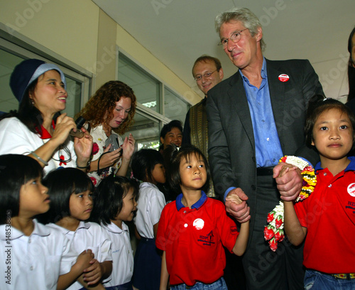 ACTOR AND AIDS ACTIVIST RICHARD GERE HOLDS HANDS OF ORPHANS WHILE VISITING THE MERCY CENTRE IN BANGKOK.