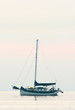 Cruising sailboat anchored out in the bay during morning sunrise