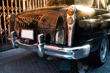 Wall Mural - Close up back view of black old vintage car or automobile back side with back light. Back side of vintage car concept.