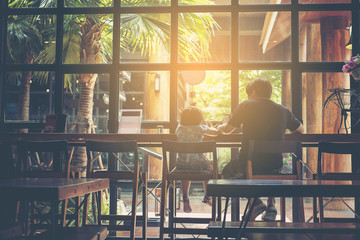 Little daughter sitting in cafe with her father