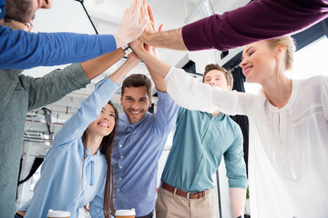 business team giving highfive together on workplace in office, young professional group concept