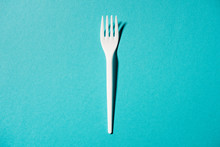 Top View Of White Plastic Fork Isolated On Blue