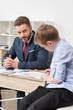 © LIGHTFIELD STUDIOS - Businessman with his son drawing on business papers at office