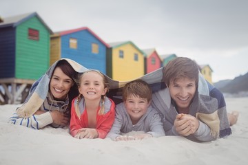 Wall Mural - Portrait of happy family lying on sand