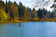 © Anton - Beautiful blue lake in a dense forest. People swim in the lake on a raft.